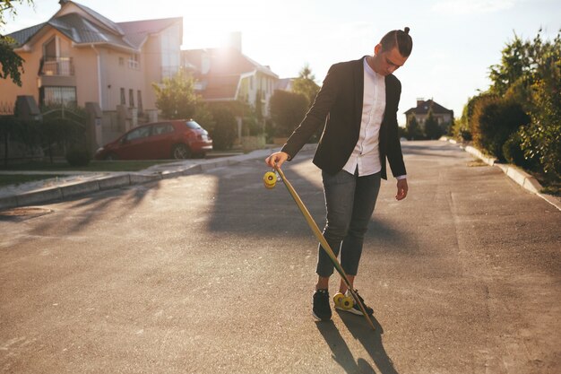 Imagem de um homem com longboard indo na estrada