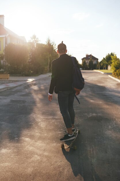 Imagem de um homem com longboard indo na estrada