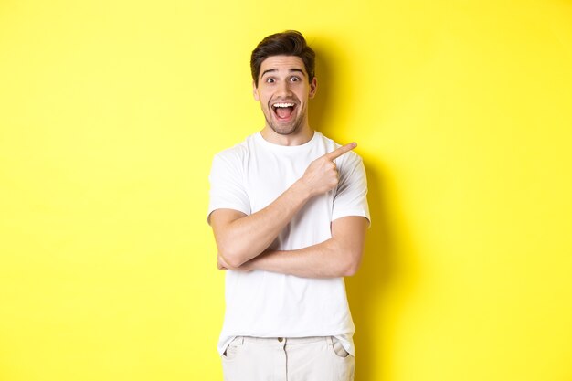 Imagem de um homem sorridente e animado mostrando ofertas de sexta-feira negra, apontando o dedo para a direita e parecendo espantado, em pé sobre um fundo amarelo.