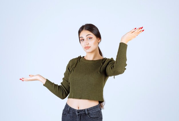 Imagem de um modelo de jovem sorridente, apontando para cima com as mãos.