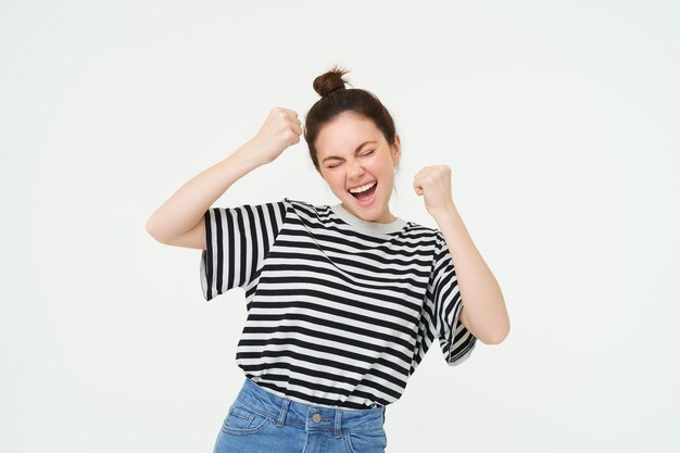 Imagem de uma jovem animada animando levantando as mãos gritando de excitação e felicidade vencendo