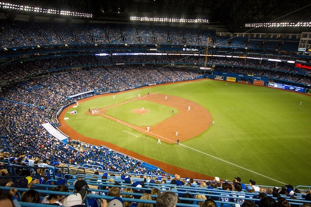 Imagem horizontal de estádio de beisebol do Yankee lotado e jogadores em campo