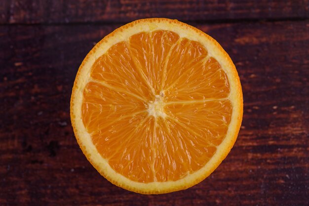 Imagem macro de laranja madura, na mesa de madeira