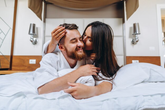 Imagem mostrando casal feliz descansando no quarto de hotel