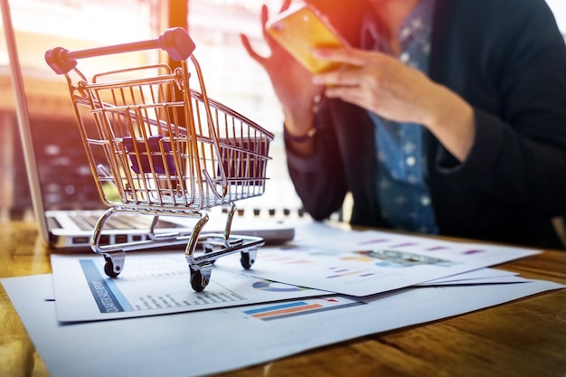 Imagem recortada da mulher que fornece informações sobre cartões e chave no telefone ou laptop enquanto faz compras on-line.