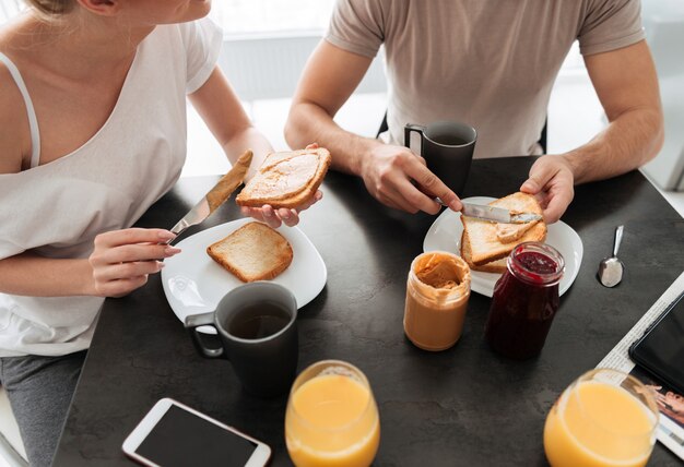 Imagem recortada de casal tomar café da manhã saboroso na cozinha