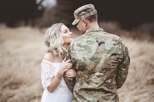 Imagem superficial de um soldado americano com sua adorável esposa em um campo