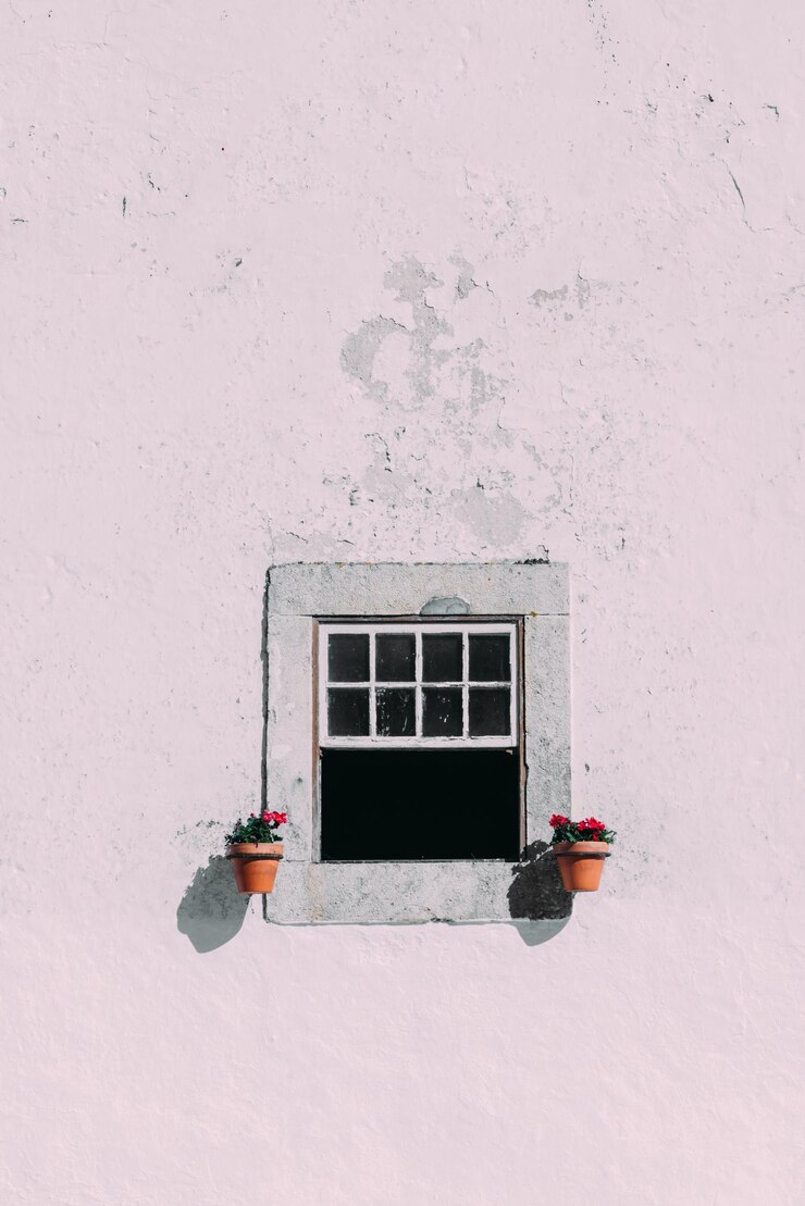 Foto grátis imagem vertical da janela de um edifício cor-de-rosa decorada com flores vermelhas em vasos de flores em óbidos