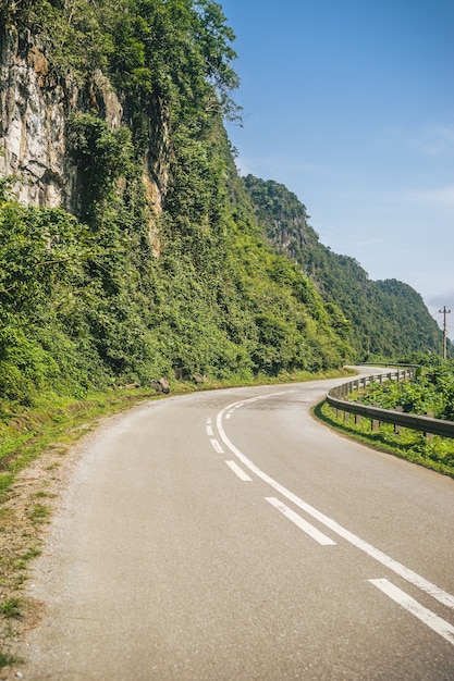 Imagem vertical de uma estrada sinuosa na encosta de uma montanha