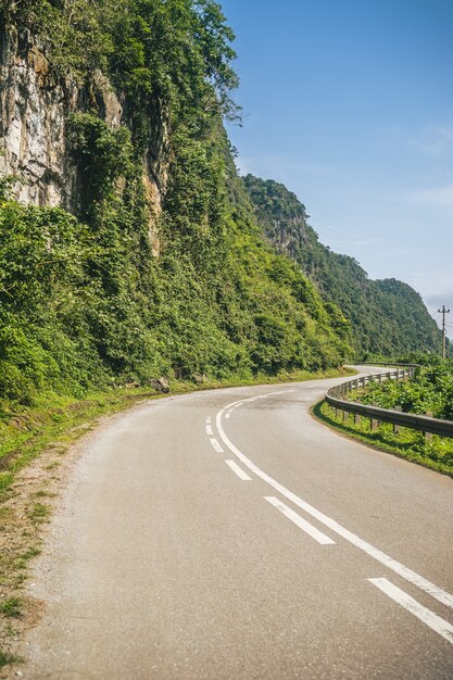 Imagem vertical de uma estrada sinuosa na encosta de uma montanha