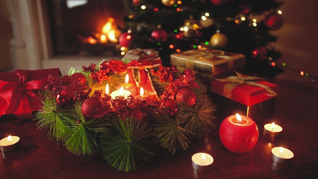 Imagens de 4k da bela guirlanda do advento decorada com velas acesas contra a brilhante árvore de natal. plano de fundo ou cenário perfeito para o natal ou ano novo Foto Premium