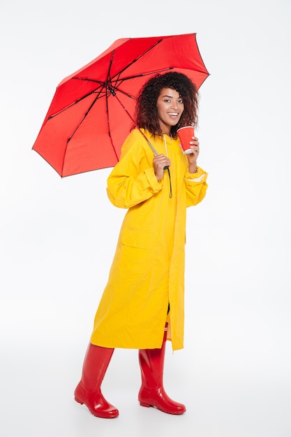 Imagens de corpo inteiro de feliz mulher africana em capa de chuva