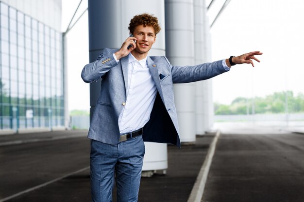 Imagens do jovem empresário ruivo, pegando o carro e falando no telefone