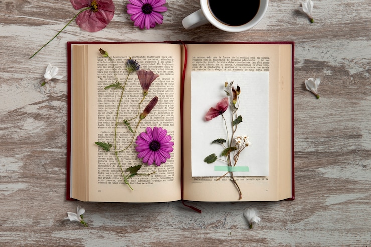Foto grátis imprensa de flores de vista superior com livro