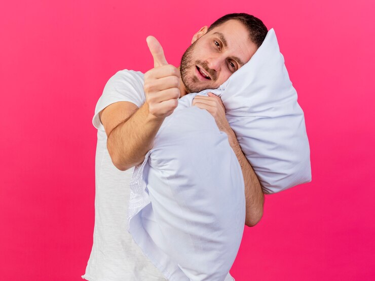Foto grátis inclinando a cabeça jovem doente abraçou o travesseiro e mostrando o polegar isolado na rosa