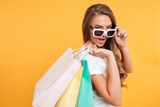 Foto grátis incrível bela jovem segurando sacolas de compras.