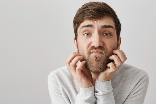 Indeciso e pensativo coçando a barba e parecendo complicado