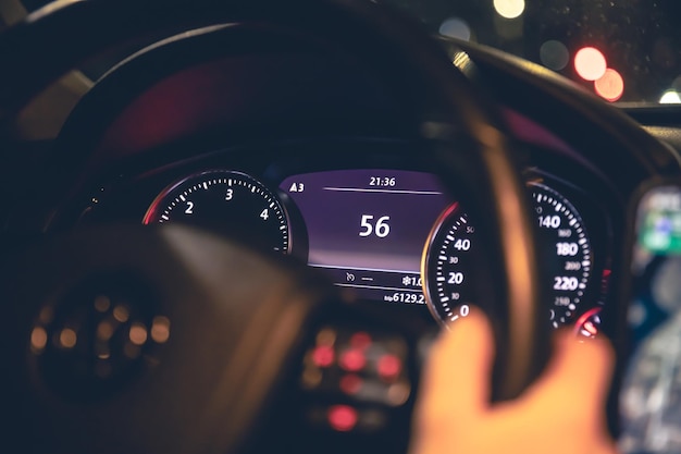 Foto grátis indicação de velocidade e mãos de mulher no volante de um carro à noite