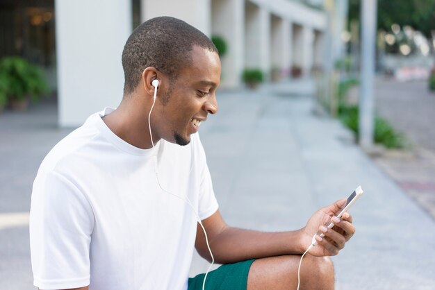 Indivíduo preto apto de sorriso que relaxa após o movimento da manhã.