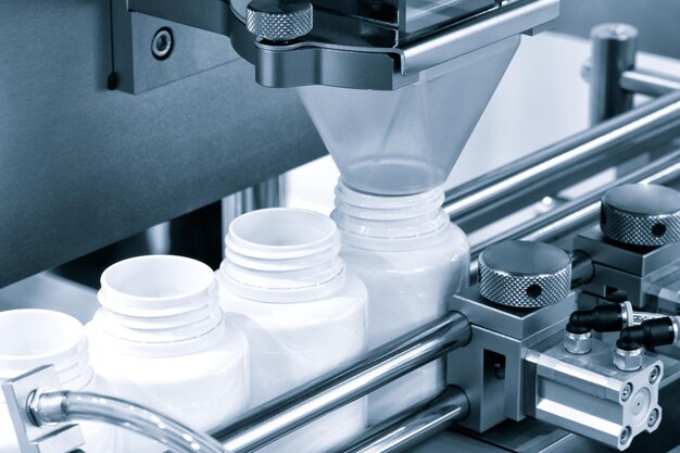 Indústria farmacêutica, pílulas de remédio estão enchendo a garrafa na esteira da máquina de linha de produção na fábrica médica. foco seletivo.