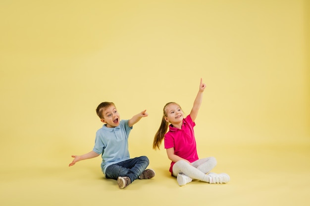 Infância e sonho com futuro grande e famoso Crianças bonitas isoladas em fundo amarelo do estúdio