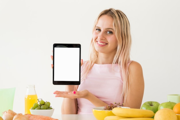 Foto grátis inflamador loira mostrando o tablet em branco