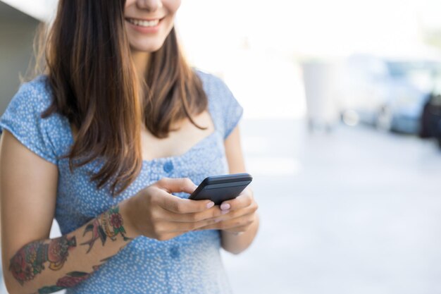 Influenciador hispânico sorridente usando smartphone no shopping