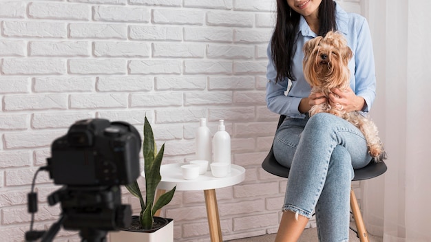 Influenciadora feminina em casa com cachorro