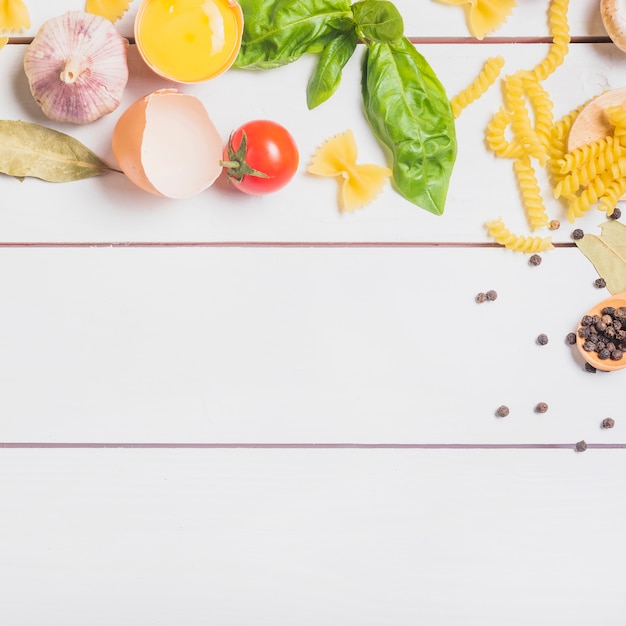 Foto grátis ingredientes para fazer massa caseira crua na prancha de madeira