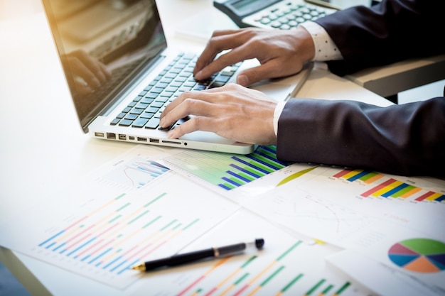 Início do processo de trabalho. Empresário que trabalha na mesa de madeira com novo projeto de finanças. Caderno moderno na mesa. Caneta segurando a mão