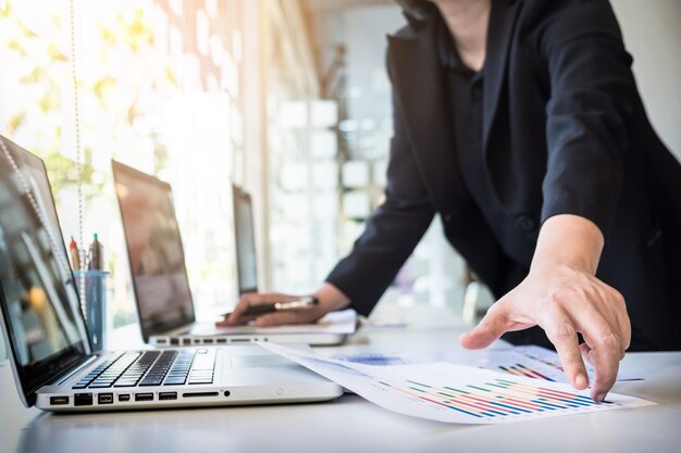 Início do processo de trabalho. Empresário que trabalha na mesa de madeira com novo projeto de finanças. Caderno moderno na mesa. Caneta segurando a mão