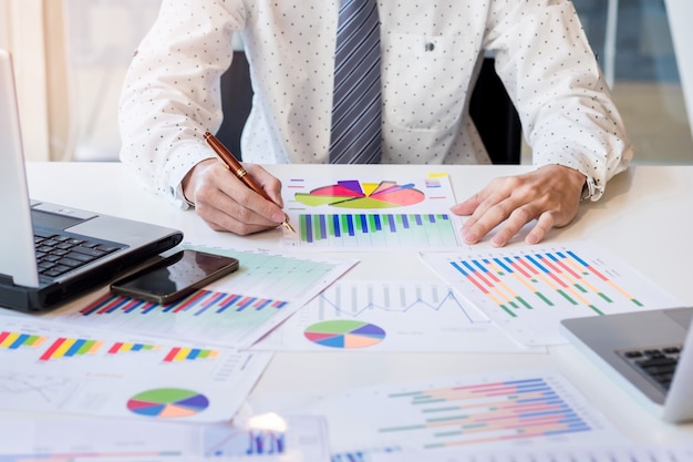 Início do processo de trabalho. empresário que trabalha na mesa de madeira com novo projeto de finanças. caderno moderno na mesa. caneta segurando a mão