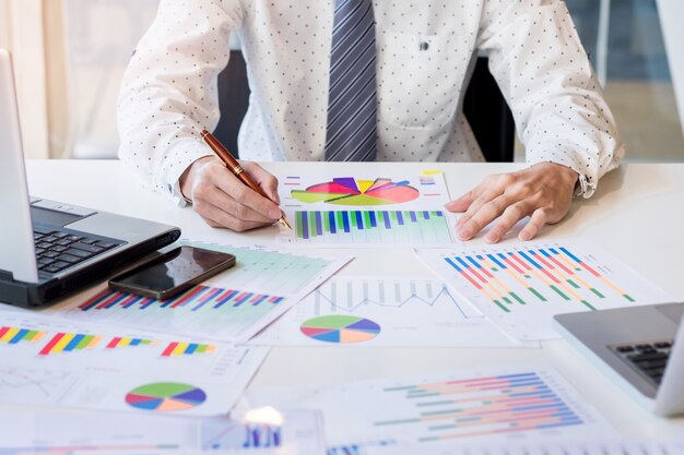 Início do processo de trabalho. Empresário que trabalha na mesa de madeira com novo projeto de finanças. Caderno moderno na mesa. Caneta segurando a mão