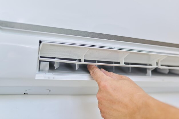 Instalando um ar condicionado em um escritório de apartamento, close-up da mão de um engenheiro instalador com uma unidade interna