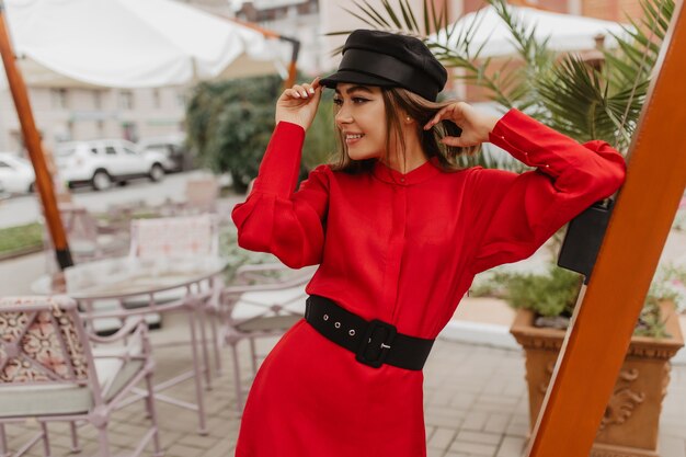 Instantâneo no estilo parisiense de jovem fashionista. Menina com corte de cabelo curto confortável posa com ousadia para foto de rua