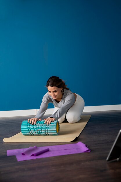 Instrutor de fitness feminino usando tablet para dar uma aula em casa