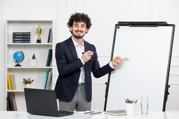 Instrutor de professor morena com computador de terno e quadro branco em sala de aula apontando para o quadro