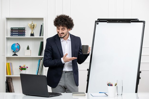 Instrutor de professor morena com computador de terno e quadro branco em sala de aula com xícara de café