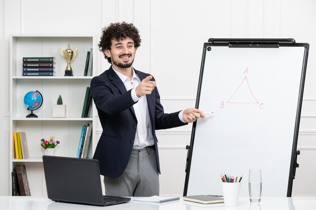 Instrutor morena professor com computador de terno e quadro branco em sala de aula sorrindo e falando