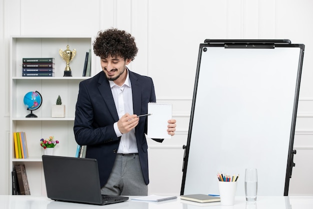 Instrutor morena professor com computador de terno e quadro branco em sala de aula sorrindo segurando notas