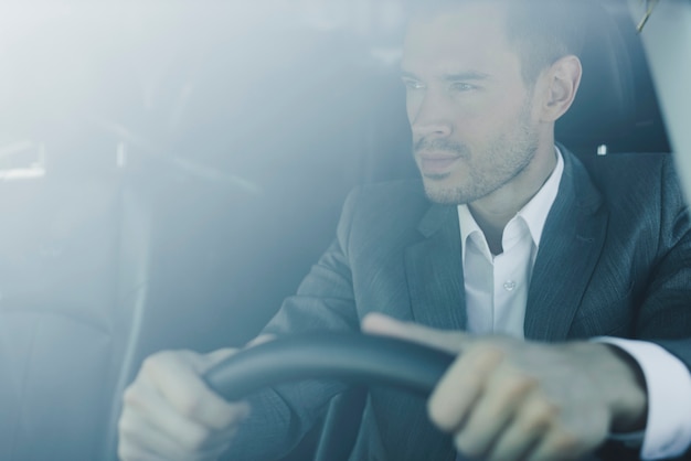 Foto grátis inteligente jovem empresário dirigindo o carro