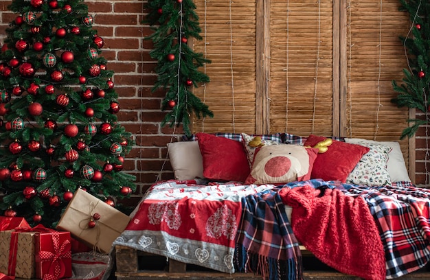 Interior do quarto de Natal com cores verde-avermelhadas e uma árvore de Natal