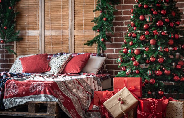 Interior do quarto de Natal com cores verde-avermelhadas e uma árvore de Natal