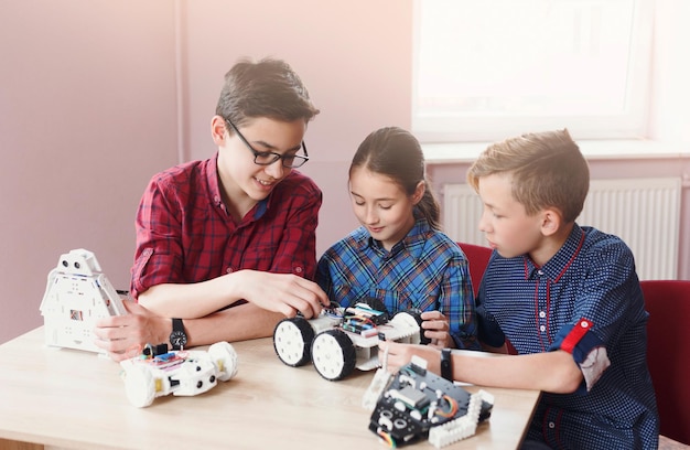 Invenções e criatividade para crianças. crianças em idade escolar brincando com robôs na aula de ciências. desenvolvimento inicial, faça você mesmo, inovação, educação integrada, conceito de tecnologia moderna