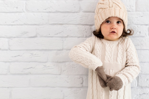 Foto grátis inverno vestido menina ao lado de uma parede