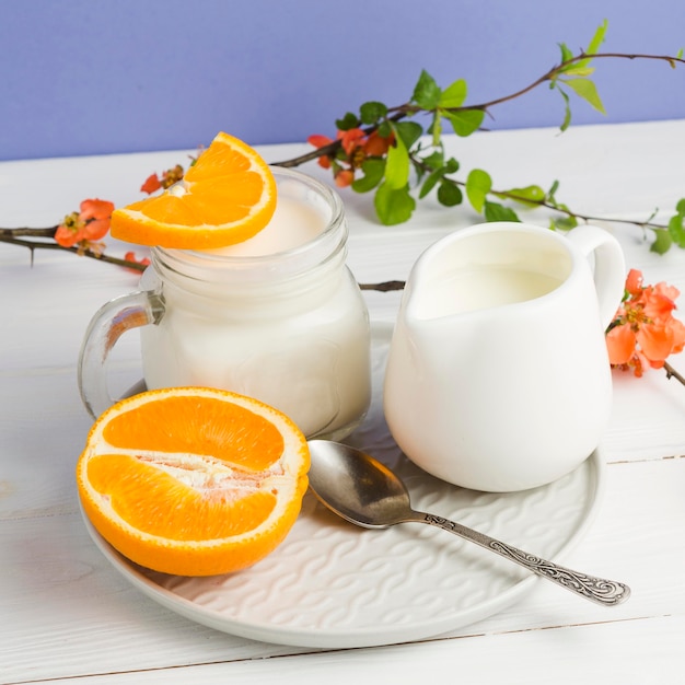 Iogurte de close-up e fatias de laranja
