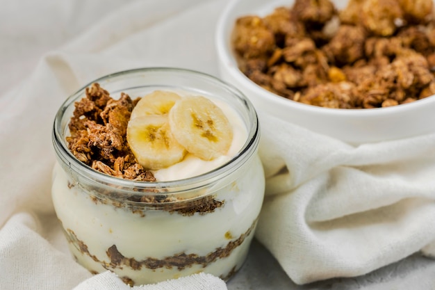 Iogurte delicioso de close-up com granola e banana