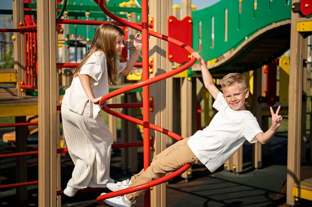 Irmão e irmã se divertindo no playground ao ar livre