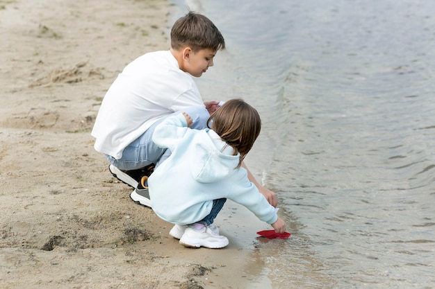 Irmãos brincando à beira do lago