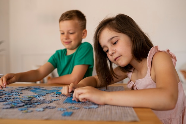 Foto grátis irmãos brincando com brinquedos de quebra-cabeça